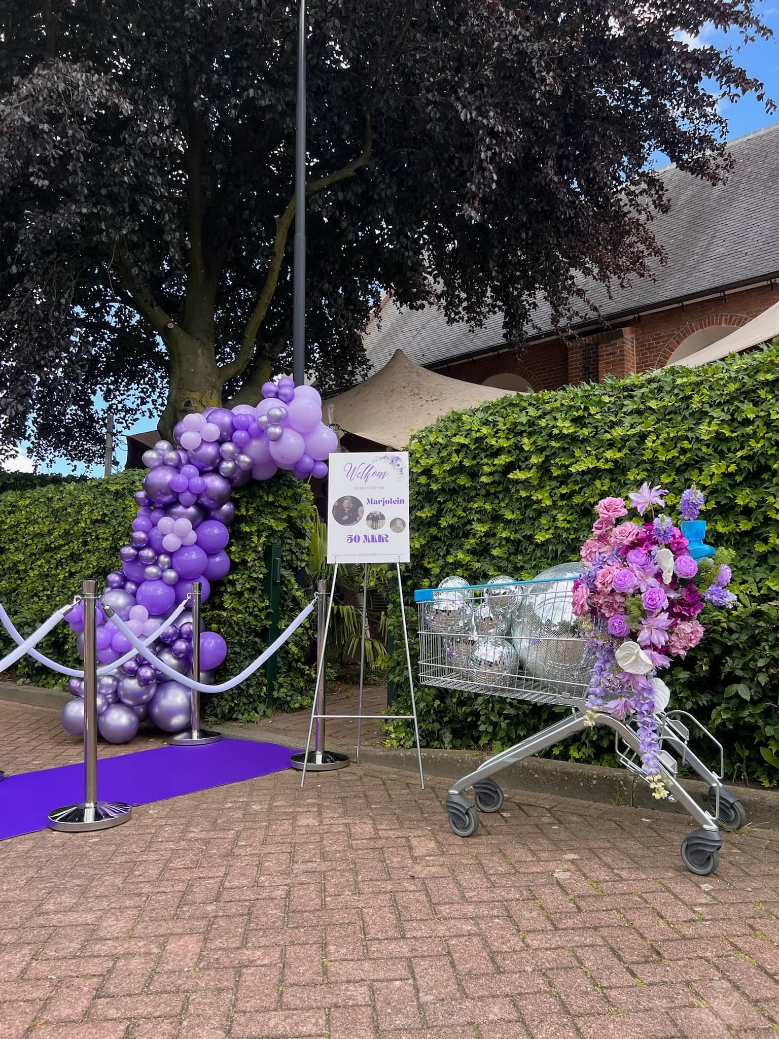 Paarse ballonboog met versierde winkelwagen