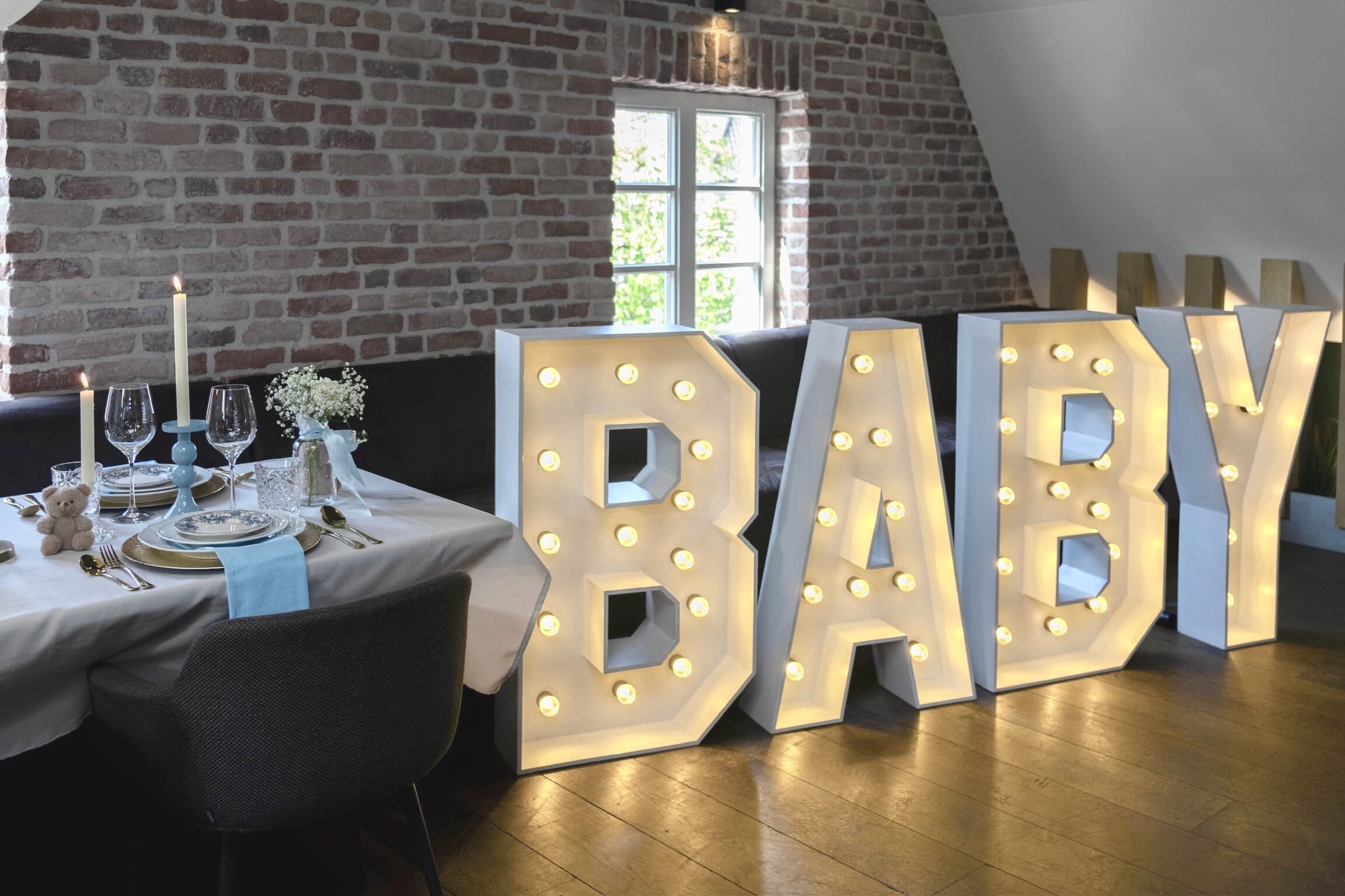 Lichtletters BABY naast een gedekte tafel