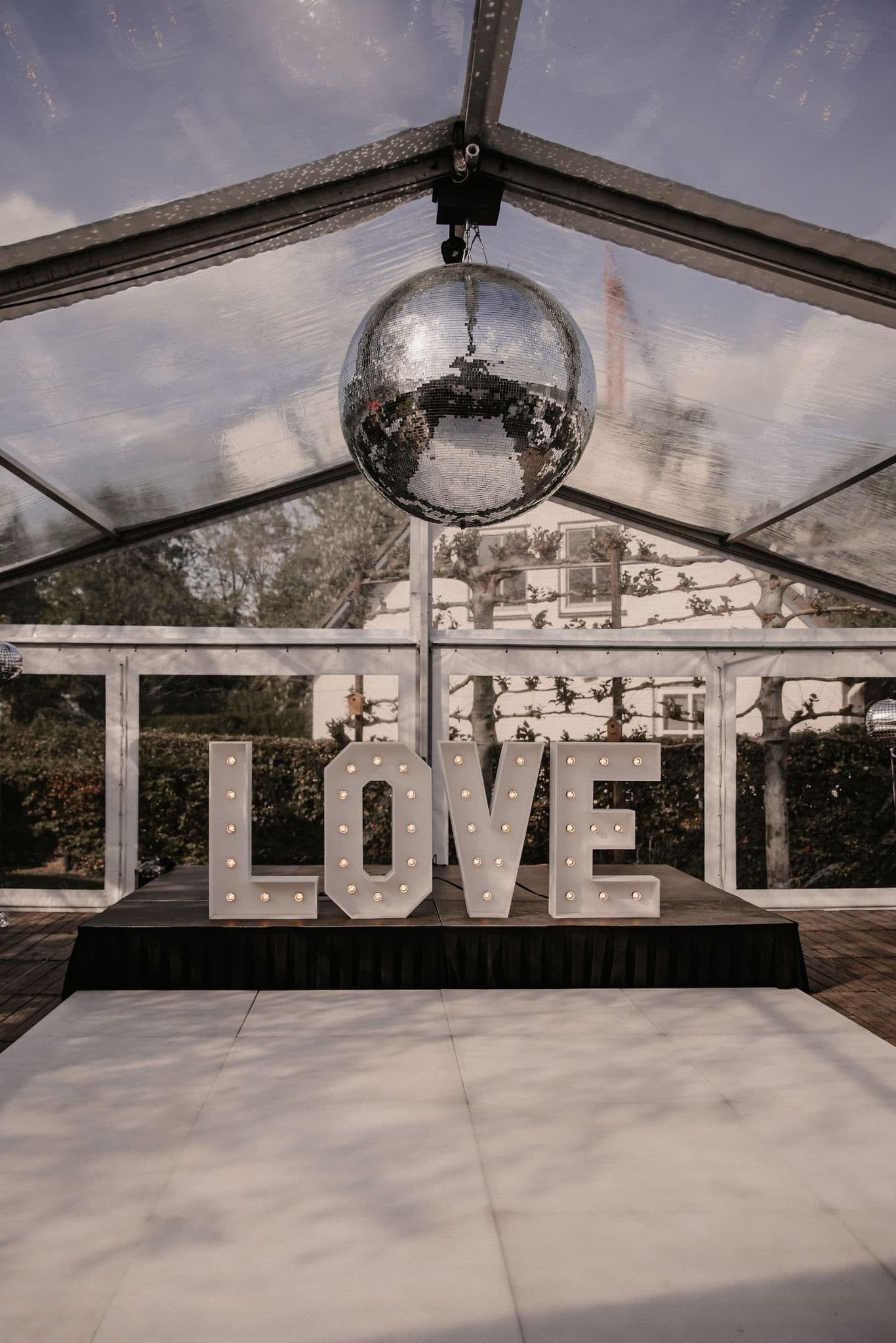 Lichtletters LOVE onder een discobal in een transparante tent
